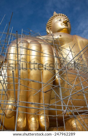 Gold buddha statue under construction  in Thai temple with clear sky.WAT MUANG, Ang Thong, THAILAND.