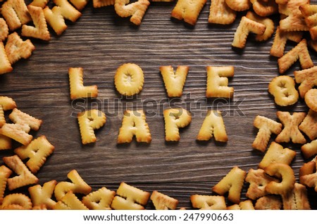 Cookies ABC in the form of word LOVE PAPA alphabet on old wood background, Valentines day