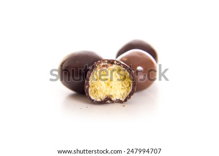 Dark brown chocolate balls and half with crisp filling over white background Royalty-Free Stock Photo #247994707