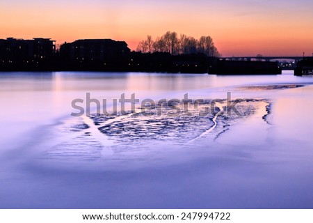 Long exposure photo of a river with an islet at sunset