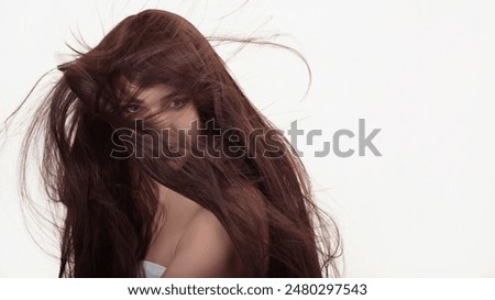 Model with beautiful healthy long hair showcasing flowing locks, isolated on white background. Beauty and hair care products. Copy space available.