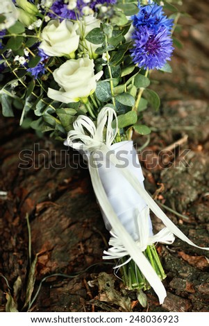 Wedding bouquet of cornflowers and roses on the tree