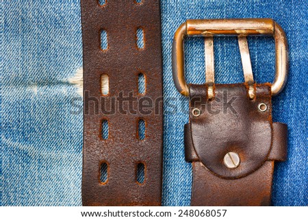 vintage leather belt on a denim background, close up