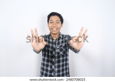 portrait of satisfied asian man excited to give okay signs isolated