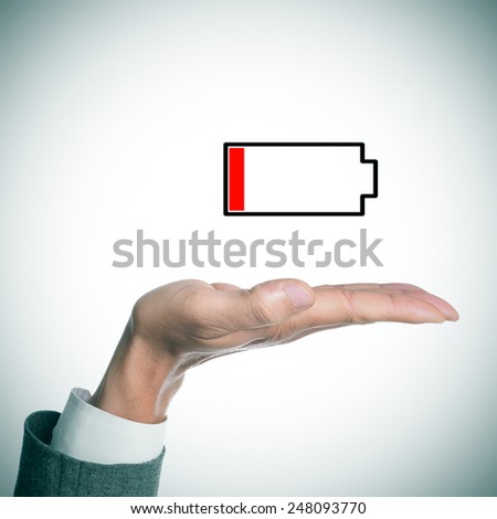 the hand of a businessman holding an illustration of a low battery