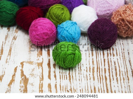 color woolen clews for knitting on a wooden background