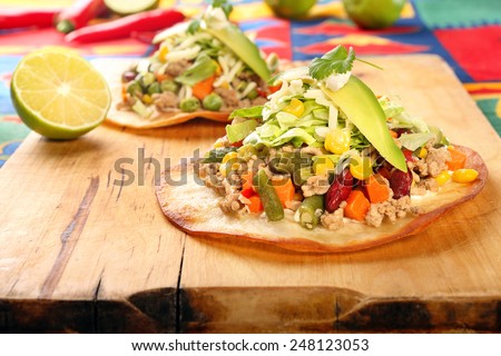 Tostadas with ground beef and vegetables on wooden background
