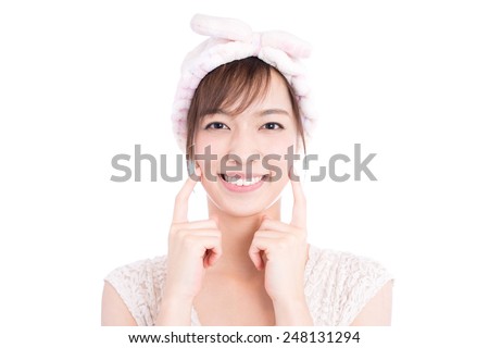young woman with hair towel touching her face, isolated on white background