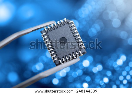 computer chip with tweezers, electronic Royalty-Free Stock Photo #248144539