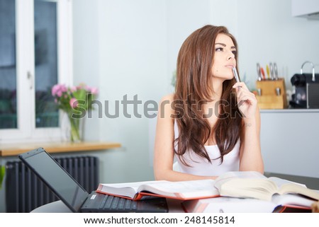 Young student woman with lots of books studying for exams