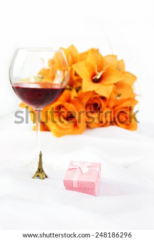 Gift Box, Little Eiffel Tower, Wineglass and Bouquet of Flowers. Focus on Gift Box.