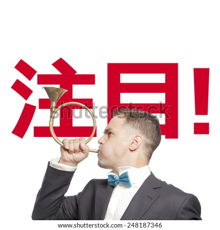 Funny man in blue bow tie blowing into the trumpet with title 'attention' mongolian language