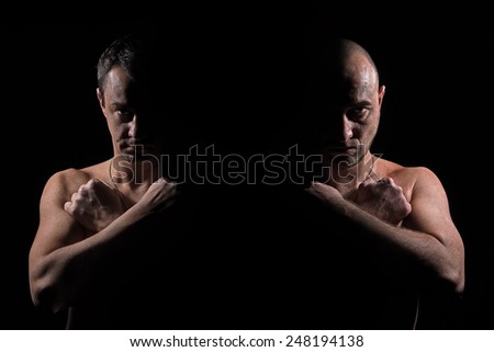Silhouette of two serious men with crossed hands in the dark