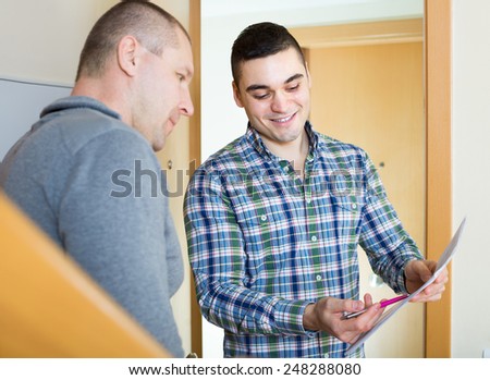 Young communal services employee asking tenant to sign a document