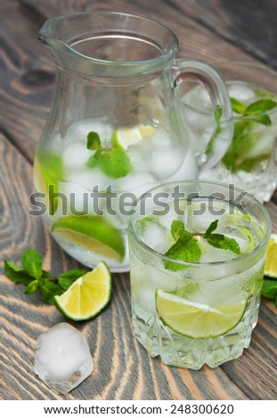 Cold fresh lemonade drink on a wooden background