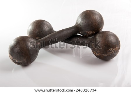 Old iron dumbbells black weights on white background in horizontal orientation, nobody.