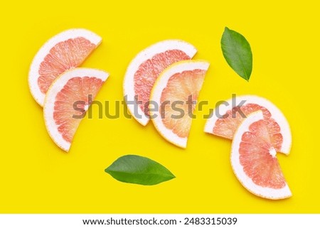Fresh red grapefruit slices on yellow background