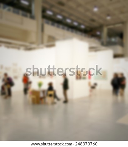 People visit art gallery. Intentionally blurred post production.