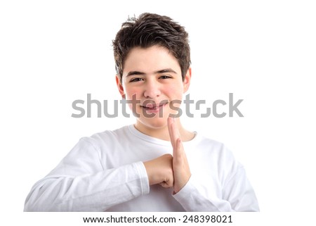 Caucasian smooth-skinned boy  in a white long sleeved t-shirt smiles making punching a palm gesture