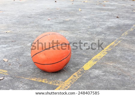 Basketball is placed on the cement floor.