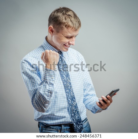Excited young man looking towards a cell phone