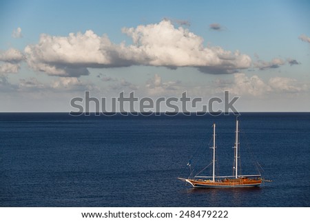 A beautiful old sailing boat in a peaceful blue sea.