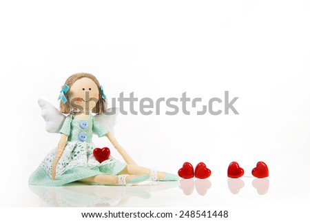 Isolated handmade doll like an angel with red hearts.