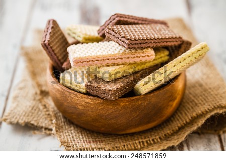 White and black wafer biscuits in wooden bowl on linen Royalty-Free Stock Photo #248571859