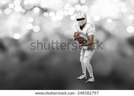 Football Player with a white uniform on a white lights background.