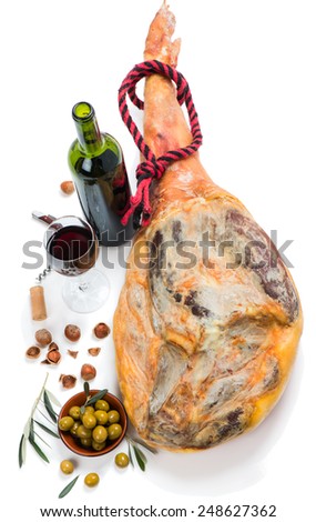Cured ham leg,  hazelnut, olives  and bottle of red wine isolated on a white background