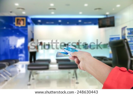 hand hold credit card on bank background 