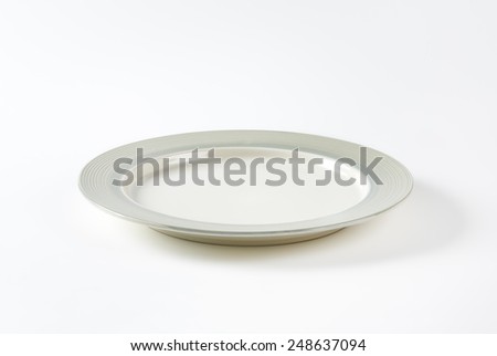 Charger plate with wide grey rim decorated with a pattern of subtle rings