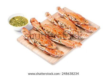 Steamed flower crab served on wooden chopping board with spicy chili dip sauce