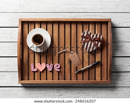 Valentine salver served with cup of coffee, gift box, word love and gift tag.  Royalty-Free Stock Photo #248656207