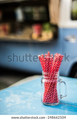 fancy red striped straws in vintage jug with custom made van selling beverage