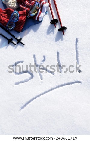 Ski background : winter vacation background with the word Ski written in snow with ski poles, goggles and bobble hats.  Space for copy in snow.  Vertical format.