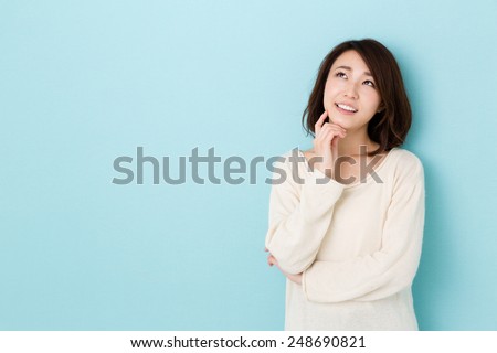 attractive asian woman thinking isolated on blue background Royalty-Free Stock Photo #248690821
