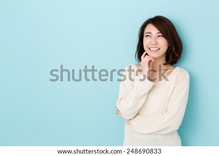 attractive asian woman thinking isolated on blue background Royalty-Free Stock Photo #248690833