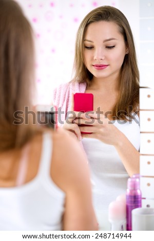 Young cute girl  taking selfie front mirror in bathroom