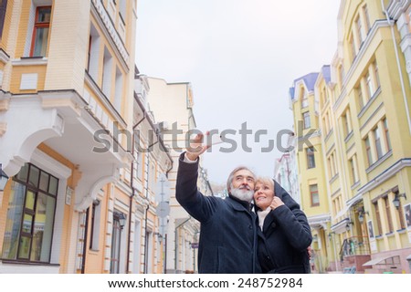 Happy Mature caucasian couple making selfie standing together on street