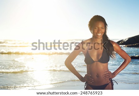 Portrait of a happy young african american woman smiling at the beach