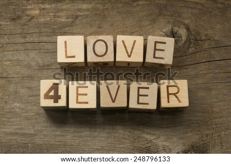 love forever text on a vintage cubes on a wooden background Royalty-Free Stock Photo #248796133