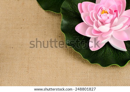Artificial lotus with leaf on brown sack background