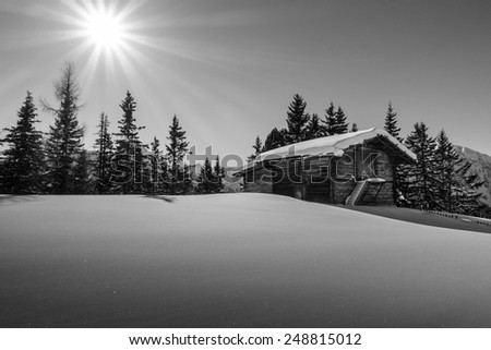 Mountain sun over the ski hut in black and white