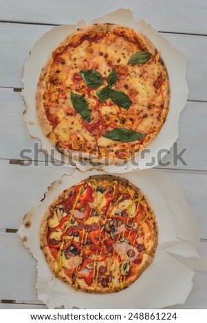 Delicious italian pizzas served on white wooden table