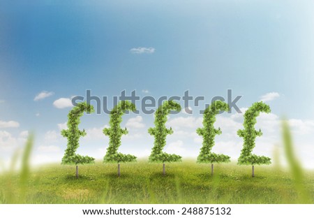 Financial growth and success on a green summer natural green grass landscape with a single trees in the shape of a money sign showing a business concept of growing prosperity and investments