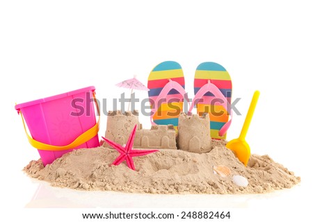 Sand castle and toys at the beach isolated over white background