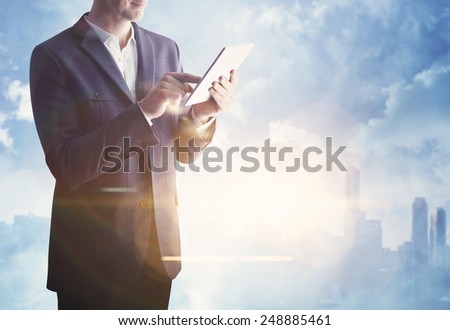 Businessman with digital tablet on blurred city background