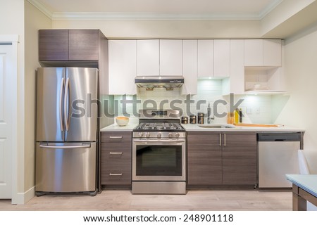 Modern, bright, clean, kitchen interior with stainless steel appliances in a luxury house Royalty-Free Stock Photo #248901118