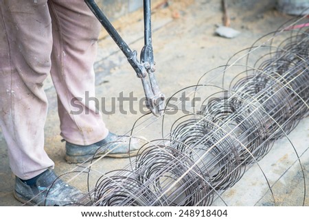 Worker cut steel with iron scissors in Construction.